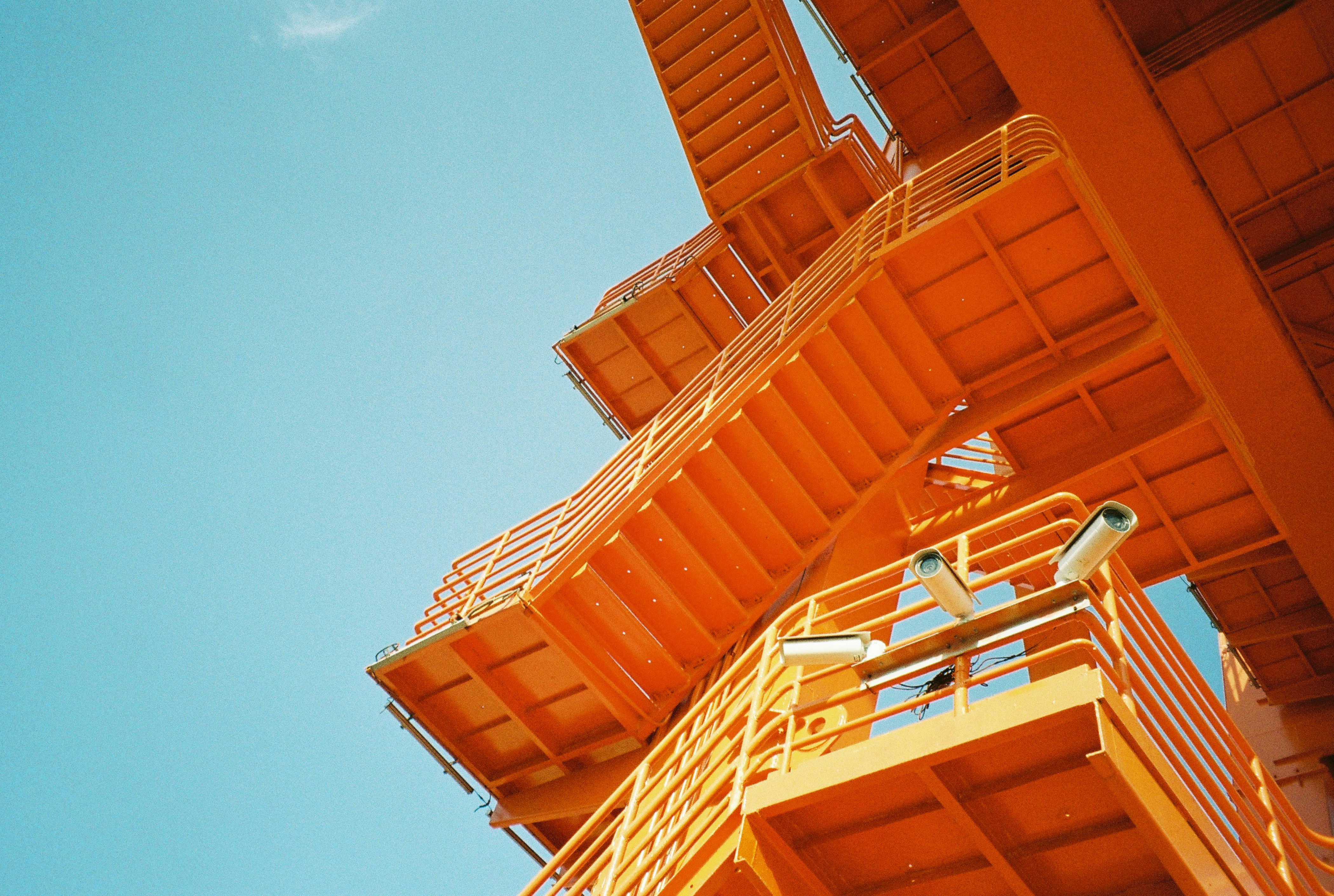 Metal staircase structure painted in organge, outdoors